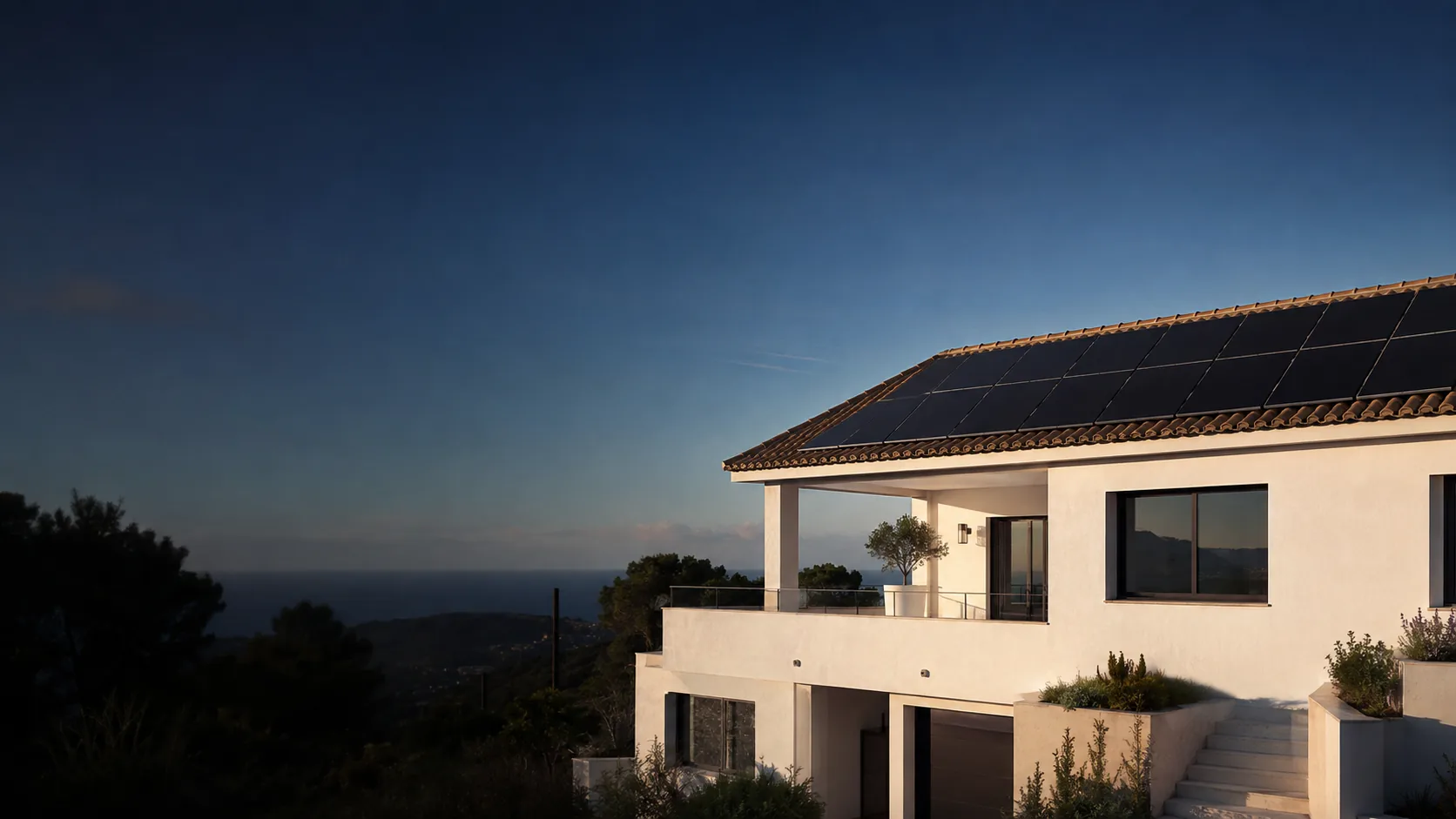White Costa del Sol villa with black solar panels on a tiled roof above the sea